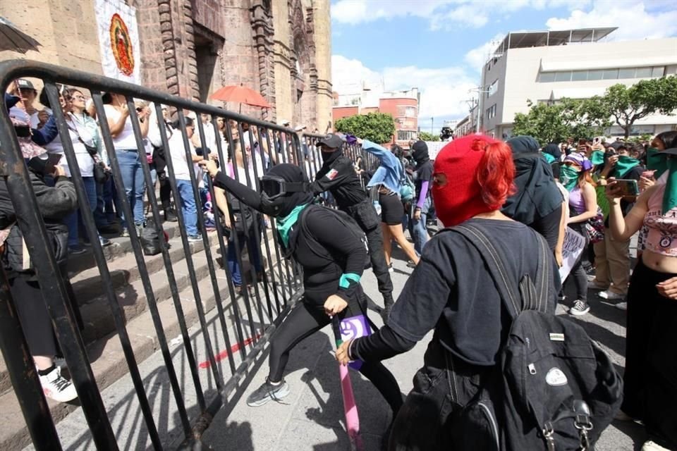 Mujeres en favor de la legalización del aborto cimbraron una valla mientras católicos protegían el Templo Expiatorio contra posibles pintas.