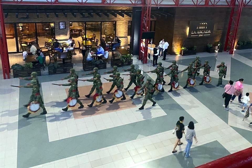 En fila, siguiendo a la banda militar, los elementos armados ingresaron a la Sala H de Cintermex, contigua a la feria librera.