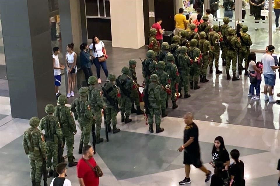 En fila, siguiendo a la banda militar, los elementos armados ingresaron a la Sala H de Cintermex, contigua a la feria librera.