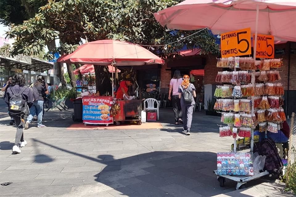 En la esquina de Insurgentes y Campeche, los puestos y las sombrillas reducen el paso peatonal.