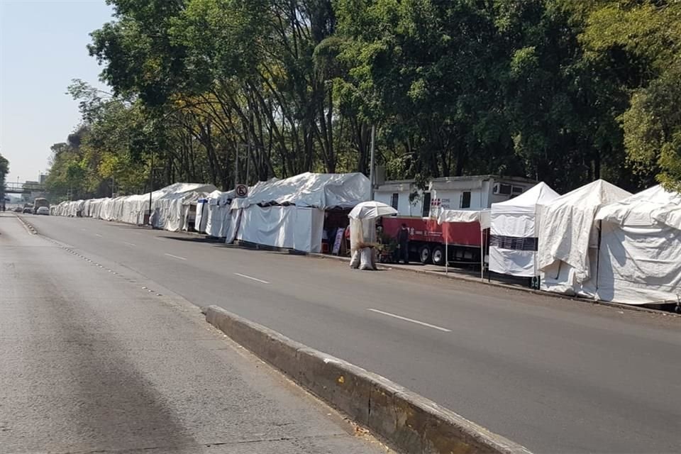 En el Parque Ramón López Velarde hay una larga fila de puestos con lonas blancas que invaden la banqueta.