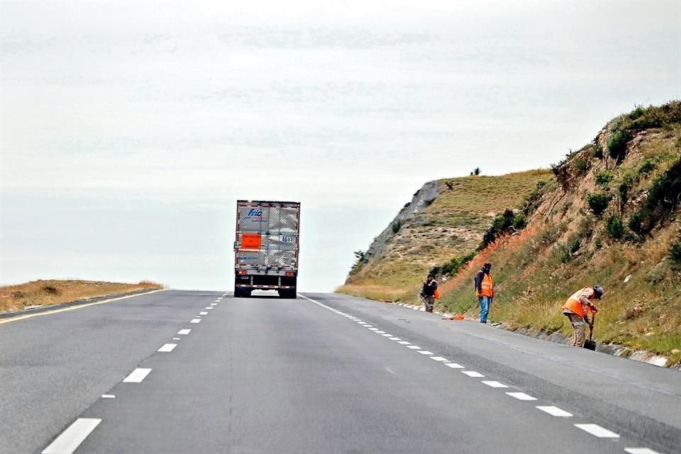 PELIGRO. Sin abanderamiento adecuado, trabajadores caminan a un costado de la Autopista a Reynosa.