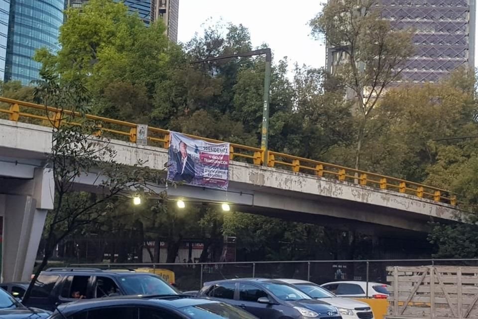 En un barandal de un paso vehicular en el Circuito Interior fue puesta una manta que invita a acudir a la marcha.