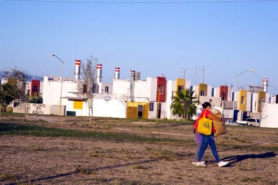 Una mujer y una menor cruzan un parque en la Colonia Valle de Sta María en Pesquería, Nuevo León.