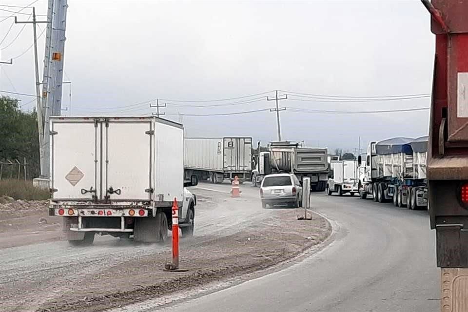 Camiones de carga y vehículos particulares permanecieron parados a la espera de que el tren se moviera.