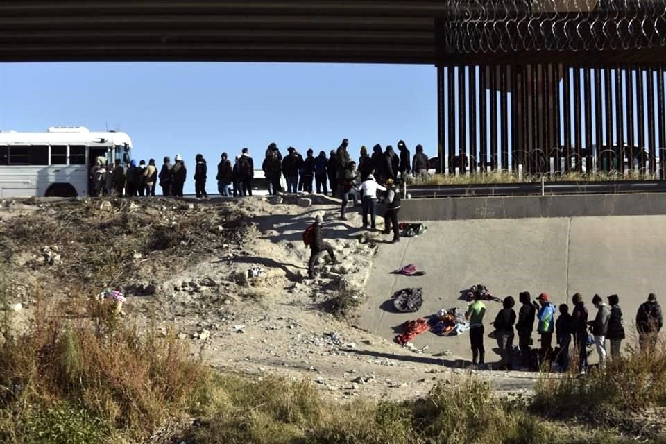 Decenas de migrantes esperan a subir a un autobús del gobierno estadounidense tras cruzar la frontera desde Ciudad Juárez, México.