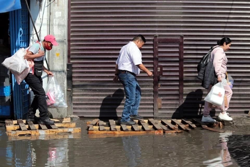 Las obras de la Línea 1 del Metro provocaron encharcamientos en la Colonia Merced, locatarios pusieron tarimas de madera para poder cruzar.