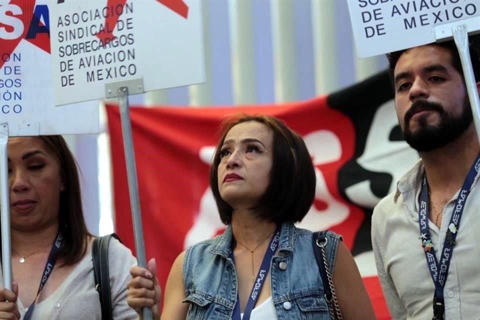 Empleados de Aeromar colocaron banderas rojinegras en los mostradores de la aerolínea y marcharon en la T2 del AICM.