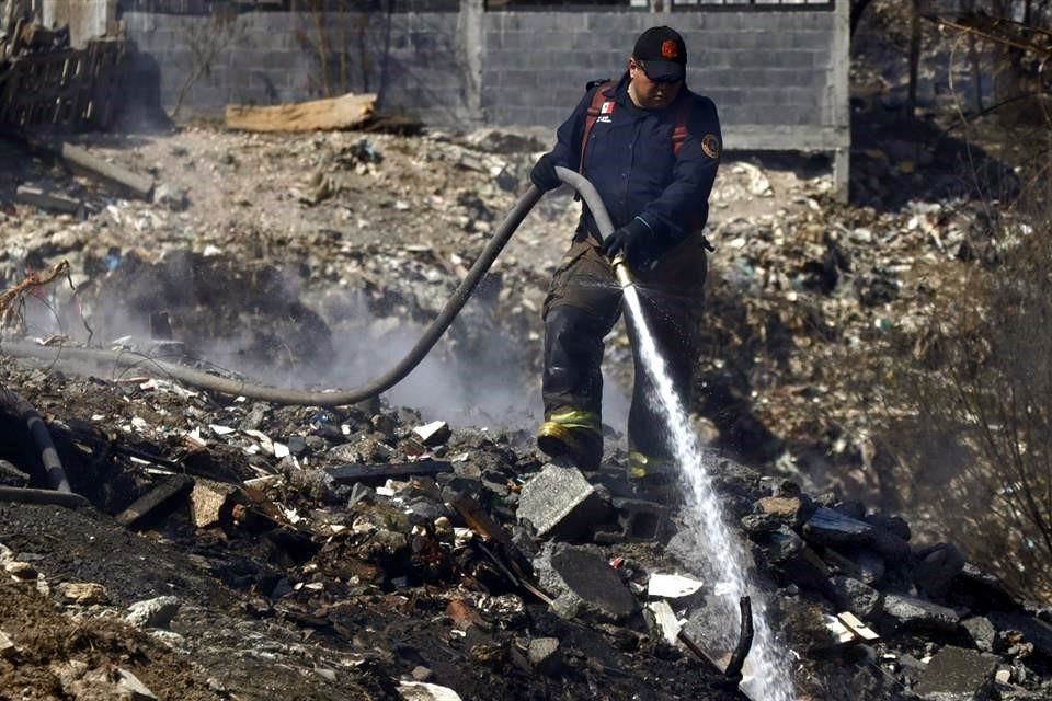 Bomberos, personal de Protección Civil y de la Secretaria de Medio Ambiente realizan diversos trabajos para sofocar un incendio en el Río Pesquería.