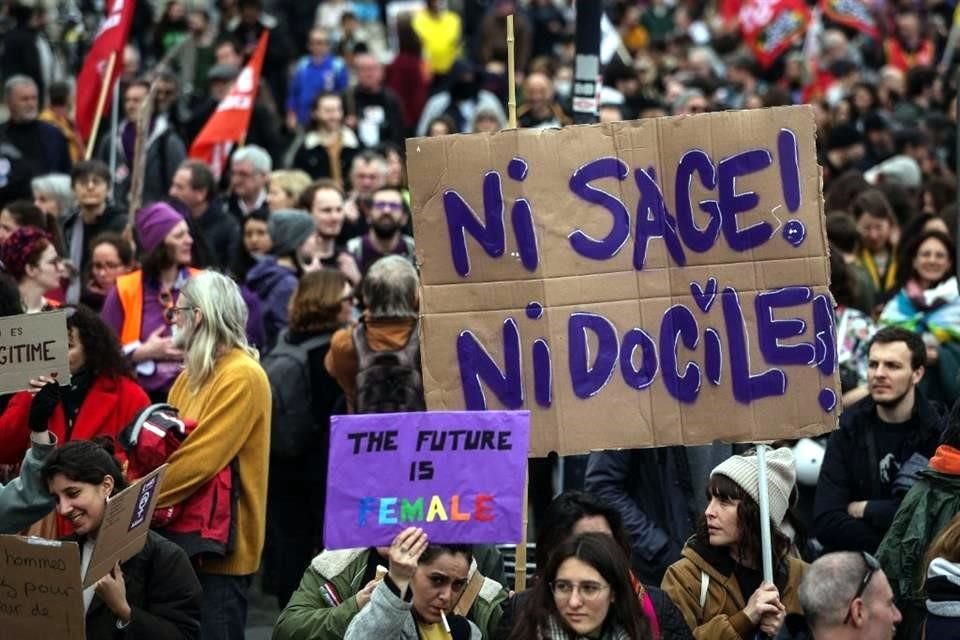 Una manifestante sostiene un cartel que dice 'ni sabio ni dócil' durante una manifestación para conmemorar el Día Internacional de la Mujer en Burdeos, Francia.