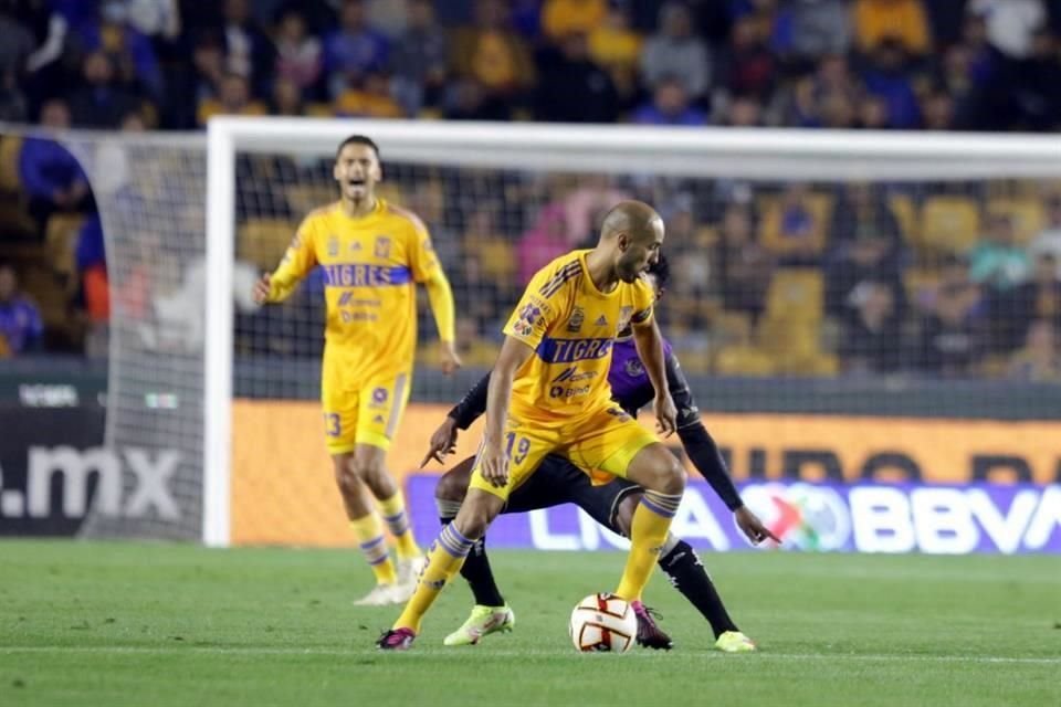 Guido Pizarro cubre el balón mientras Diego Reyes, al fondo, pega un grito.