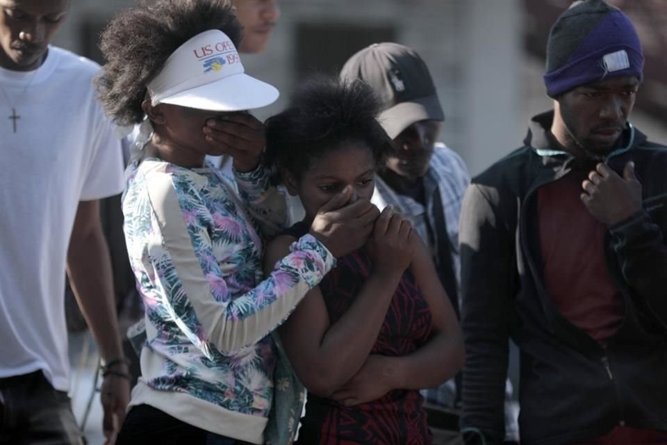 Un grupo de personas observa los cadáveres de presuntos pandilleros que fueron quemados vivos por una turba en la sección Canape Vert de Puerto Príncipe, Haití, el lunes 24 de abril de 2023.