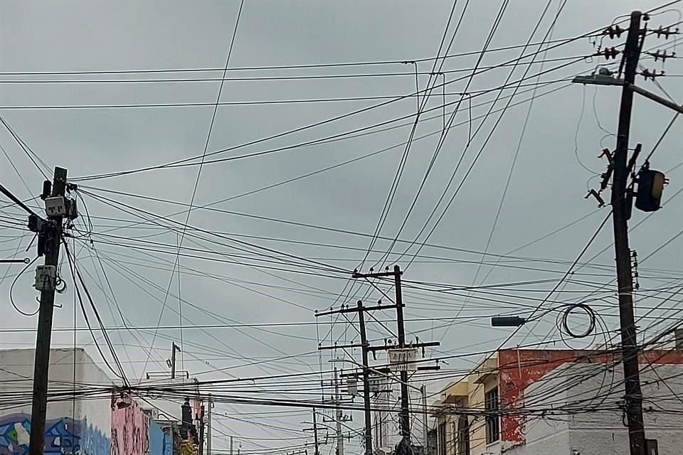 El Centro de Monterrey no es la excepción en las telarañas de cables y los postes en riesgo de caer, como en la calle Escobedo.