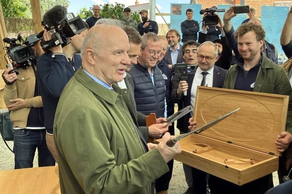 El general retirado Jean-Louis Georgelin, encargado de supervisar la reconstrucción, enseña algunas de las herramientas utilizadas en la restauración del tejado.