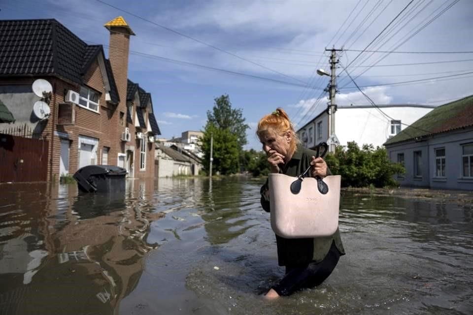 Una residente camina a través de un camino inundado después de que las paredes de la presa Kakhovka, en Jersón, se derrumbaran durante la noche.