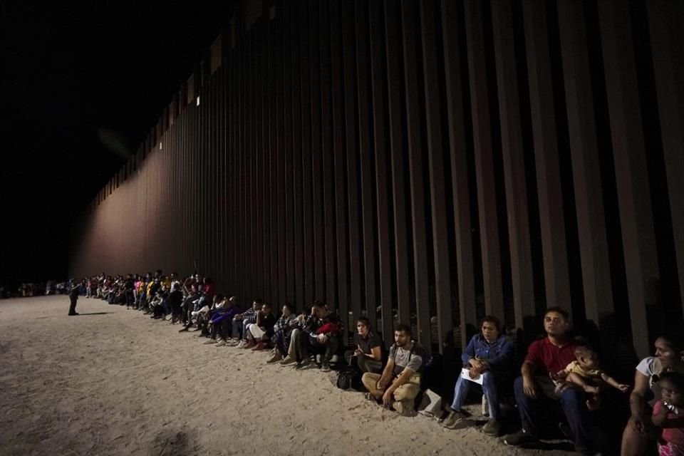 Migrantes esperan a un lado del muro fronterizo entre México y Estados Unidos, el 23 de agosto del 2022.