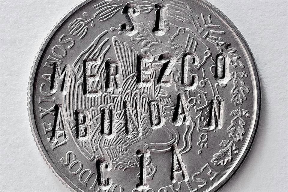 La frase 'Sí merezco abundancia' está escrita sobre monedas.