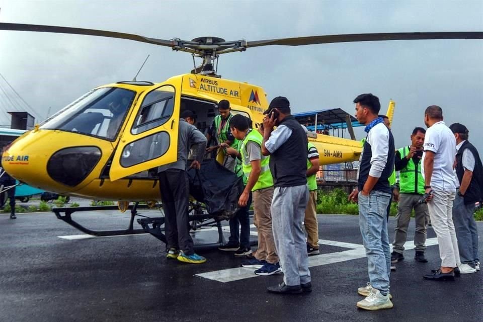 La gente descarga el cuerpo de la víctima que murieron en un accidente de helicóptero en el Hospital Docente de la Universidad de Tribhuvan en Katmandú, Nepal.