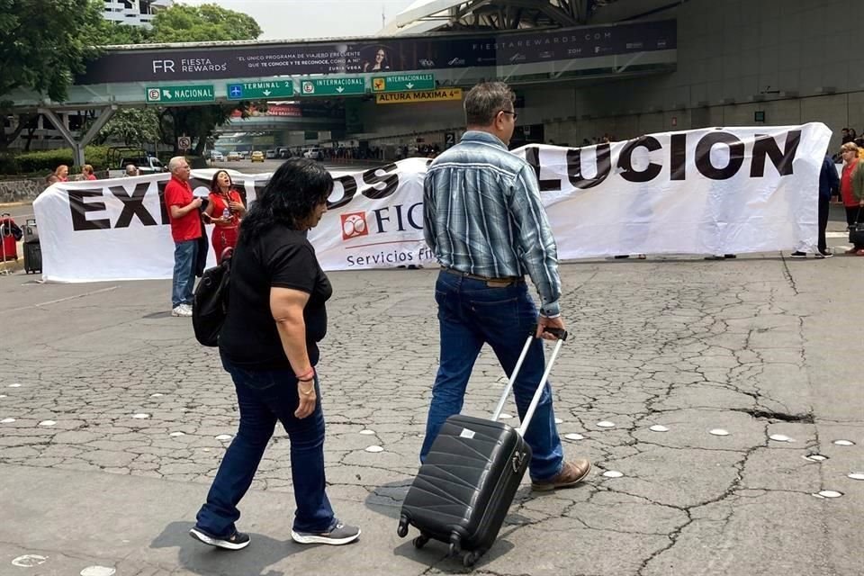 Manifestantes bloquean el acceso a la T1 del AICM por lo que policías capitalinos apoyan en traslado de usuarios a la terminal aérea.