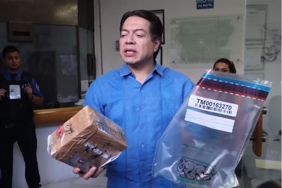 Mario Delgado muestra uno de los paquetes que contienen las boletas de la encuesta de Morena.