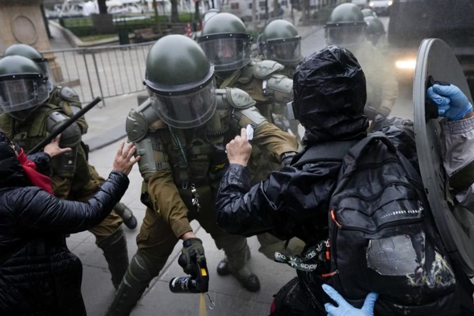 Manifestantes se enfrentan a policías durante la marcha por el 50 aniversario del golpe de estado de Augusto Pinochet.