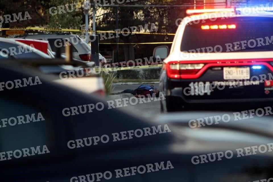 El cuerpo de la víctima quedó detrás de una camioneta.