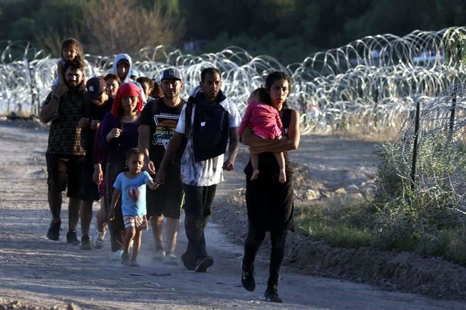 Con niños en brazos, migrantes intentan entrar a Estados Unidos.