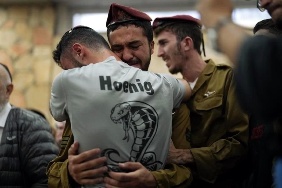 Dolientes se consuelan entre sí durante el funeral del soldado israelí Benjamin Loeb, quien también tenía nacionalidad francesa.