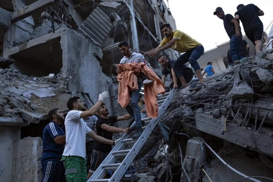 Palestinos rescatan a una niña de un edificio residencial.