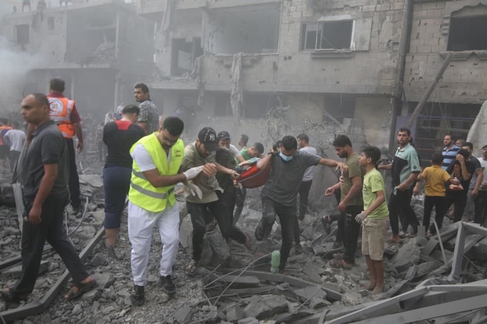 Personas rescatan a los heridos en edificios destruidos en ataques aéreos israelíes, en la ciudad de Rafah, en el sur de la Franja de Gaza.