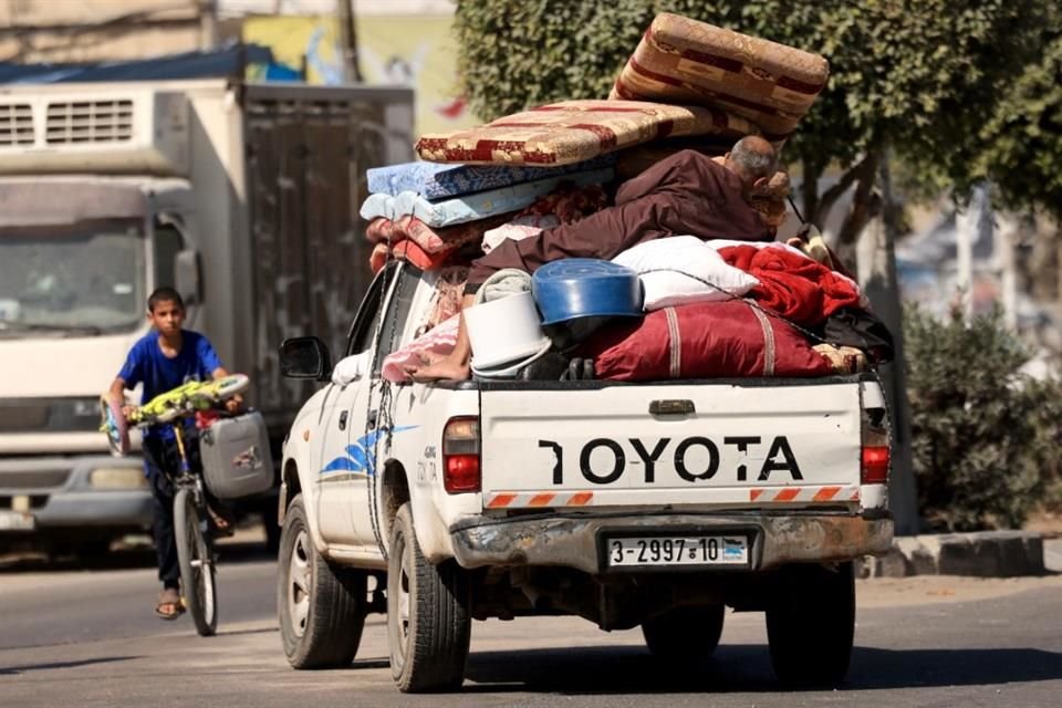 Palestinos con sus pertenencias huyen a zonas más seguras en Gaza.