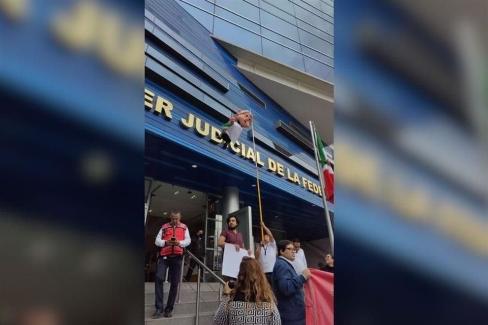 Trabajadores del Poder Judicial cuelgan una figura del Presidente López Obrador en una de las sedes.