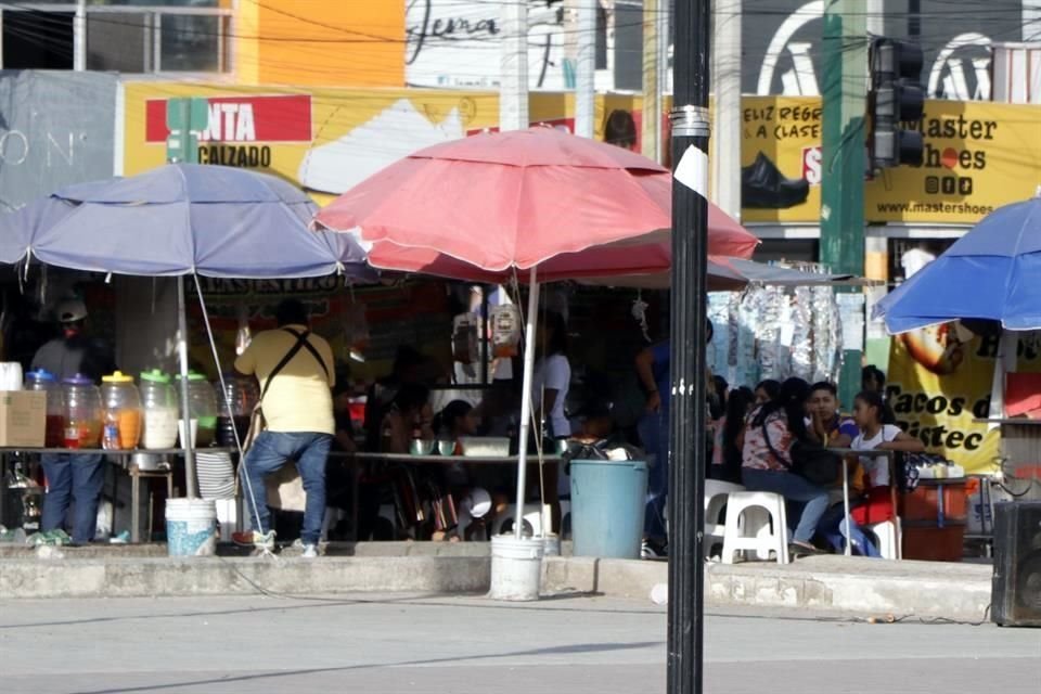 En ese cruce tres carritos de comida ocupan por completo la banqueta.