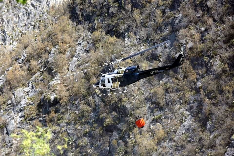 El cielo era surcado una y otra vez por helicópteros que arrojaban agua a las cimas de las sierras.