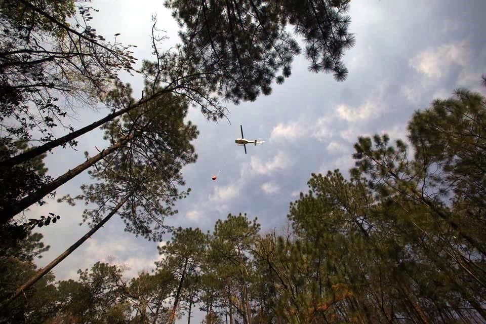 El cielo era surcado una y otra vez por helicópteros que arrojaban agua a las cimas de las sierras.