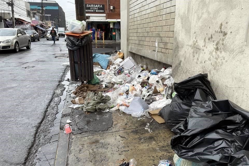 La basura tirada obliga a los peatones caminar por la calle.