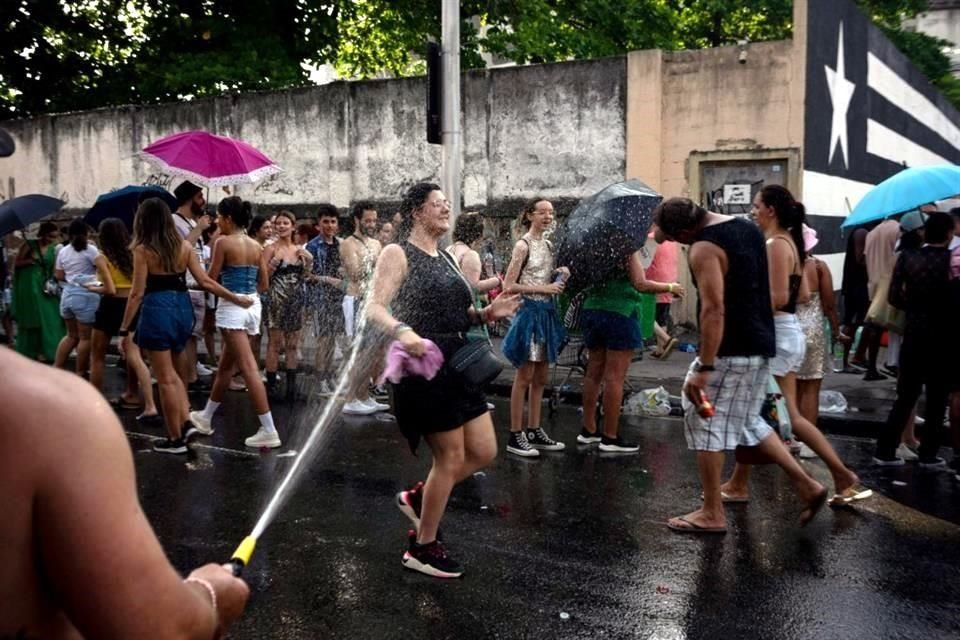 Fans de Taylor Swift se refrescan con mangueras para aguanta la ola de calor en Río de Janeiro.