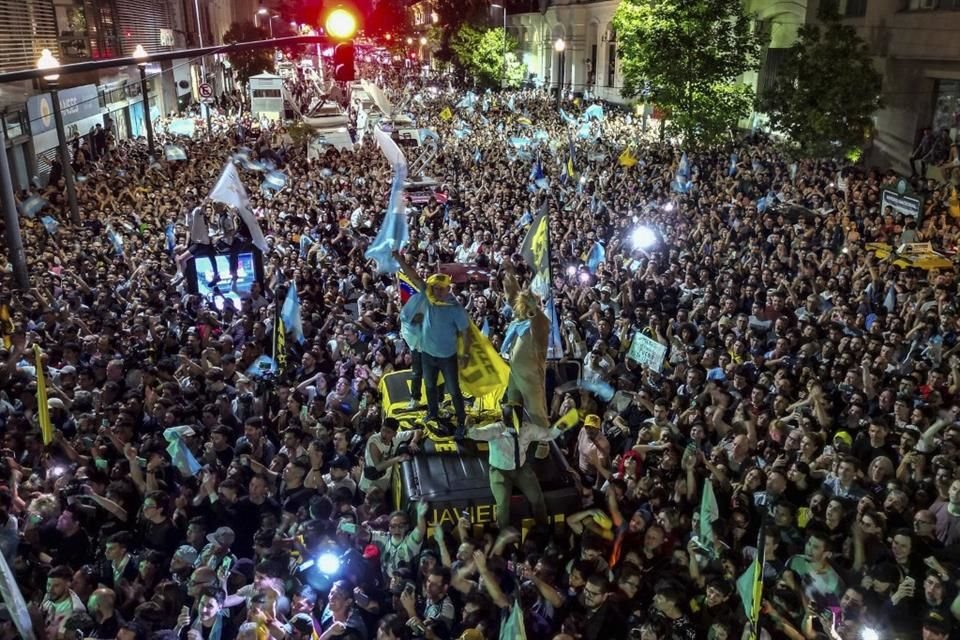 Partidarios del candidato presidencial Javier Milei celebran afuera de su sede de campaña su victoria sobre el Ministro de Economía, Sergio Massa.