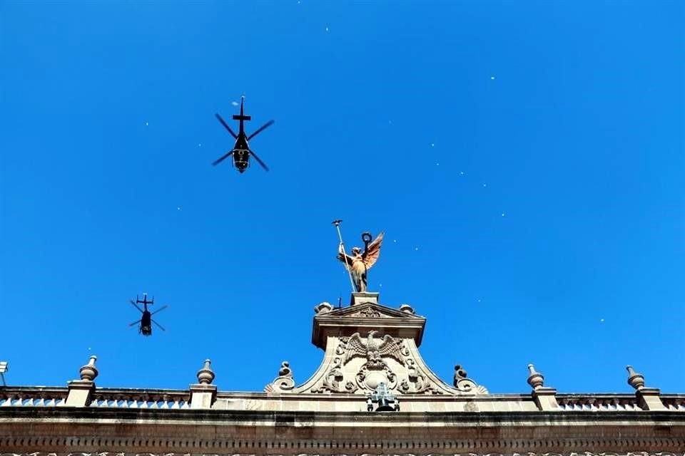 Al tiempo que continúa el desfile, sobrevuelan Palacio Nacional helicópteros de Fuerza Civil.