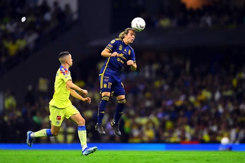 Sebastián Córdova cabecea el balón en media cancha ante la mirada de Álvaro Fidalfo.