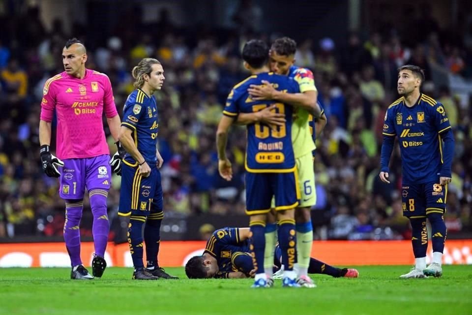 Jonathan Dos Santos abraza a Javier Aquino mientras Jesús Angulo yace en el césped.