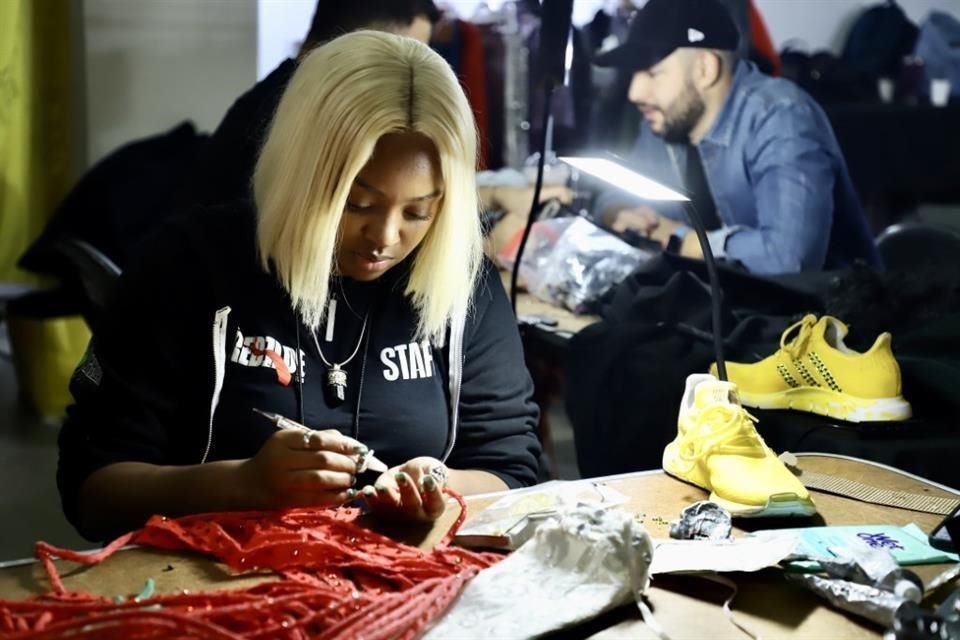 Aspecto del trabajo del equipo de vestuario del grupo RBD, quienes afinan detalles de ajuste, planchado y decorado previo al concierto en el Foro Sol.