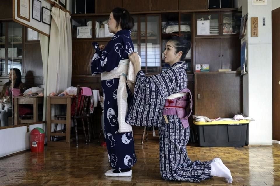 La maestra Naoko Kihara ajusta la faja de su discípula Eiko Moriya, quien busca certificarse también en la danza Hanayagi Ryu.