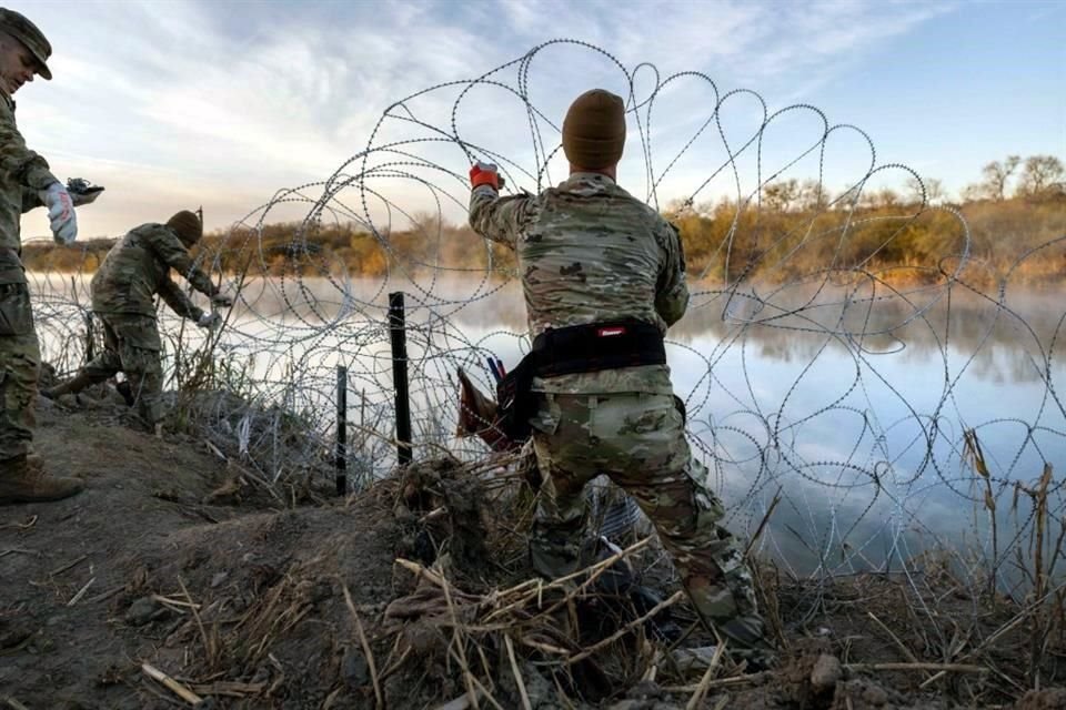 oldados de la Guardia Nacional de Texas instalan alambre de púas adicional a lo largo del Río Bravo.