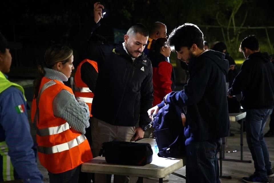 Los encargados revisan de manera visual el contenido de las mochilas.