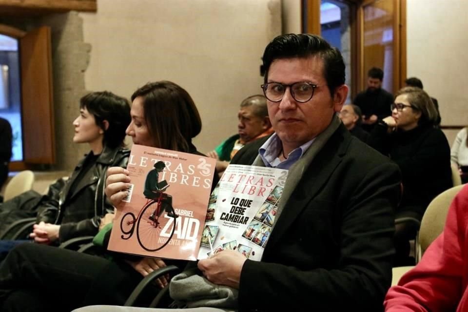 Un lector de la revista 'Letras Libres' exhibe un par de las publicaciones durante la charla de aniversario en El Colegio Nacional.