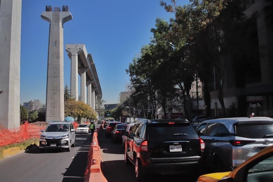 Para instalar las columnas, fueron suprimidos árboles y en el camellón sobresalen los tiraderos de cascajo bajo la estructura del tren.