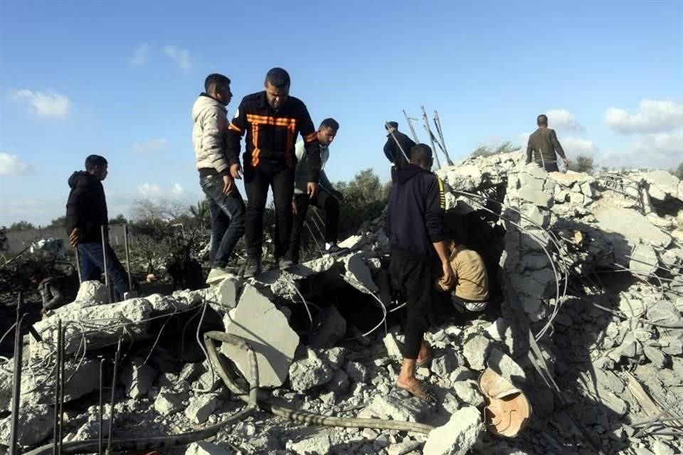 Palestinos buscan sobrevivientes después de un ataque aéreo israelí contra un edificio residencial en Rafah, Franja de Gaza.