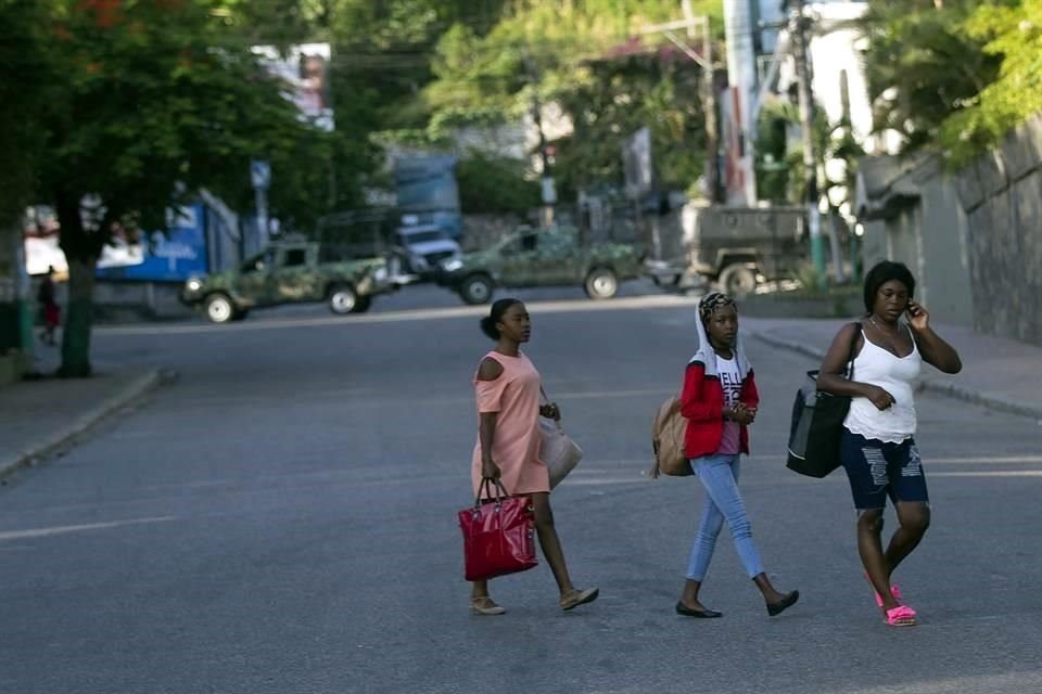 Personas caminan cerca de un bloqueo militar en  Petion Ville, el vecindario donde vivía el  Presidente Jovenel Moise.