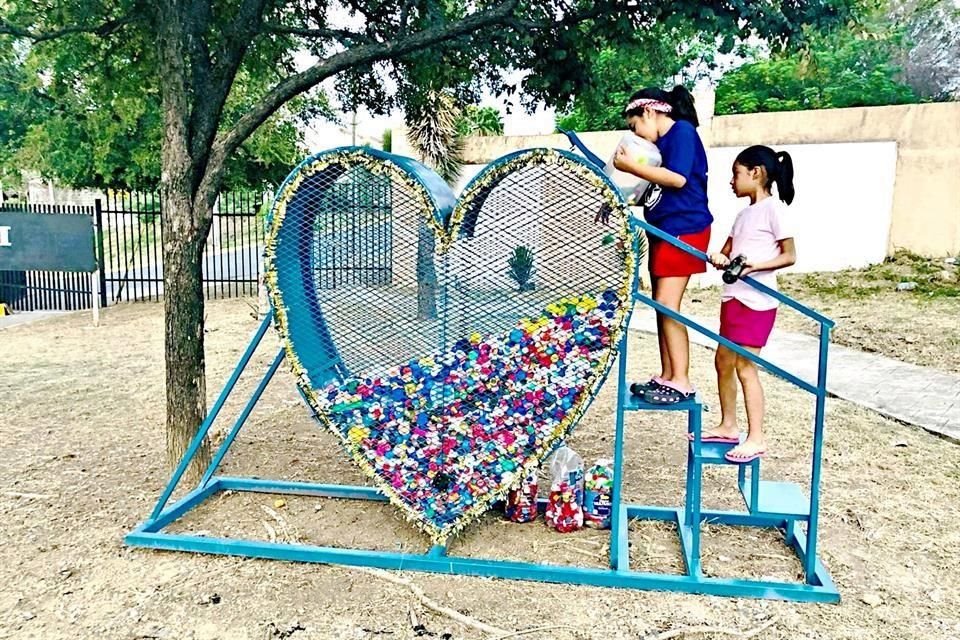 Algunos de los corazones para depositar tapitas en la Ciudad han sido elaborados por ciudadanos, como éste, de Luis de León y sus hijas.
